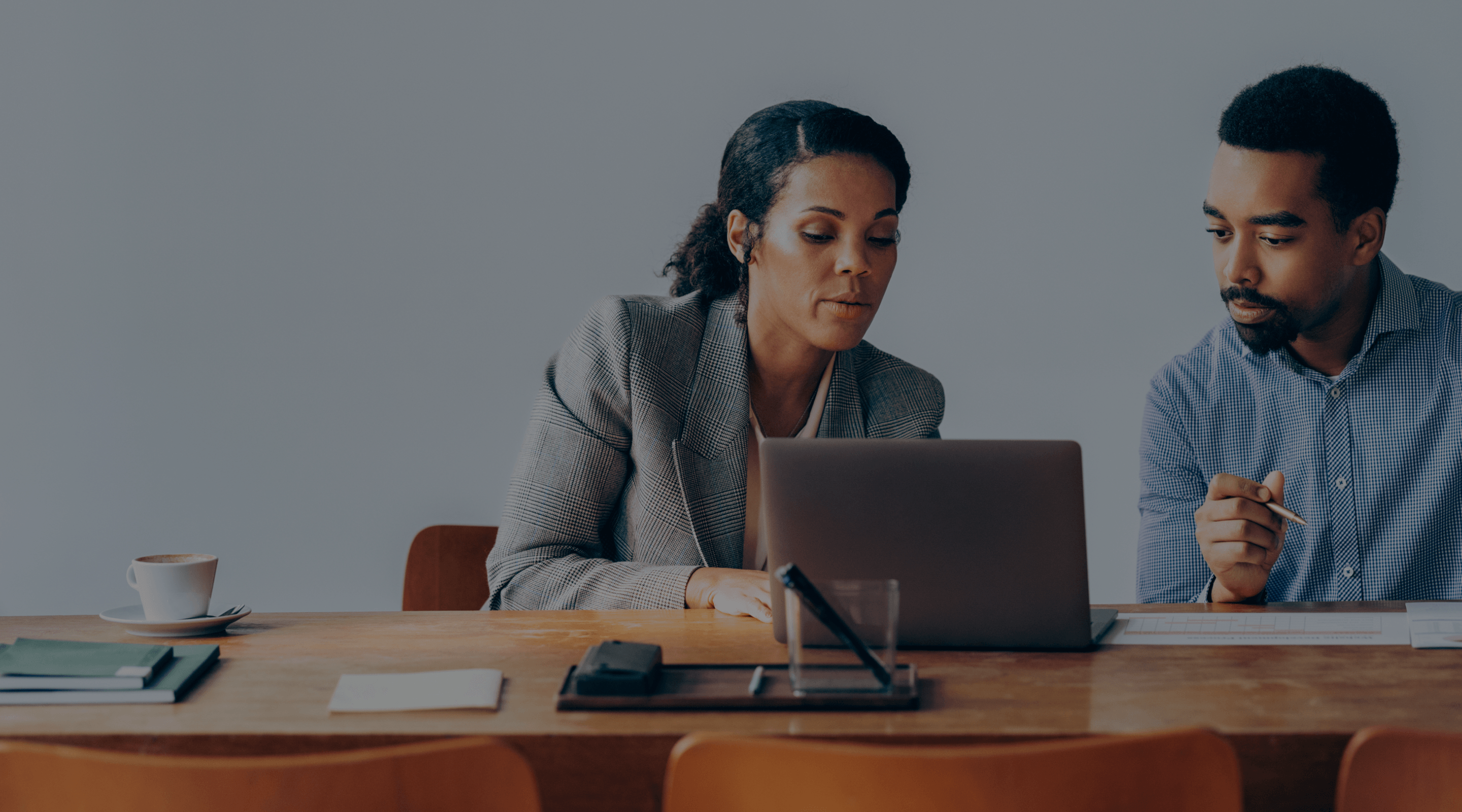 Image of two people working at a desk.