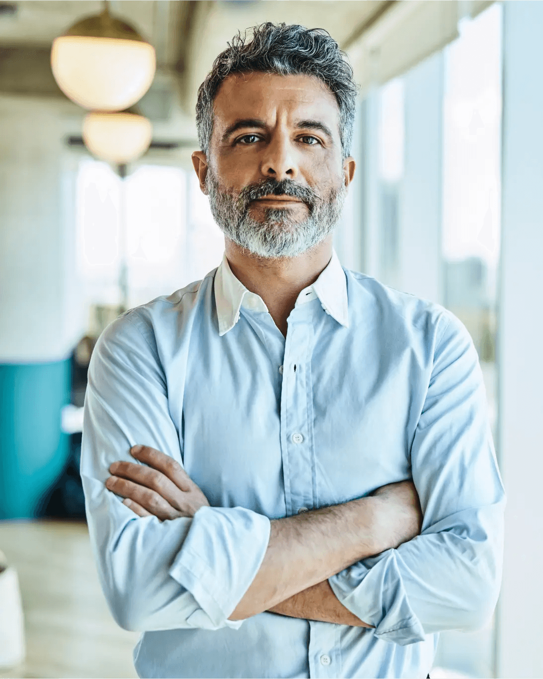 A man with his arms crossed in front of a wind.