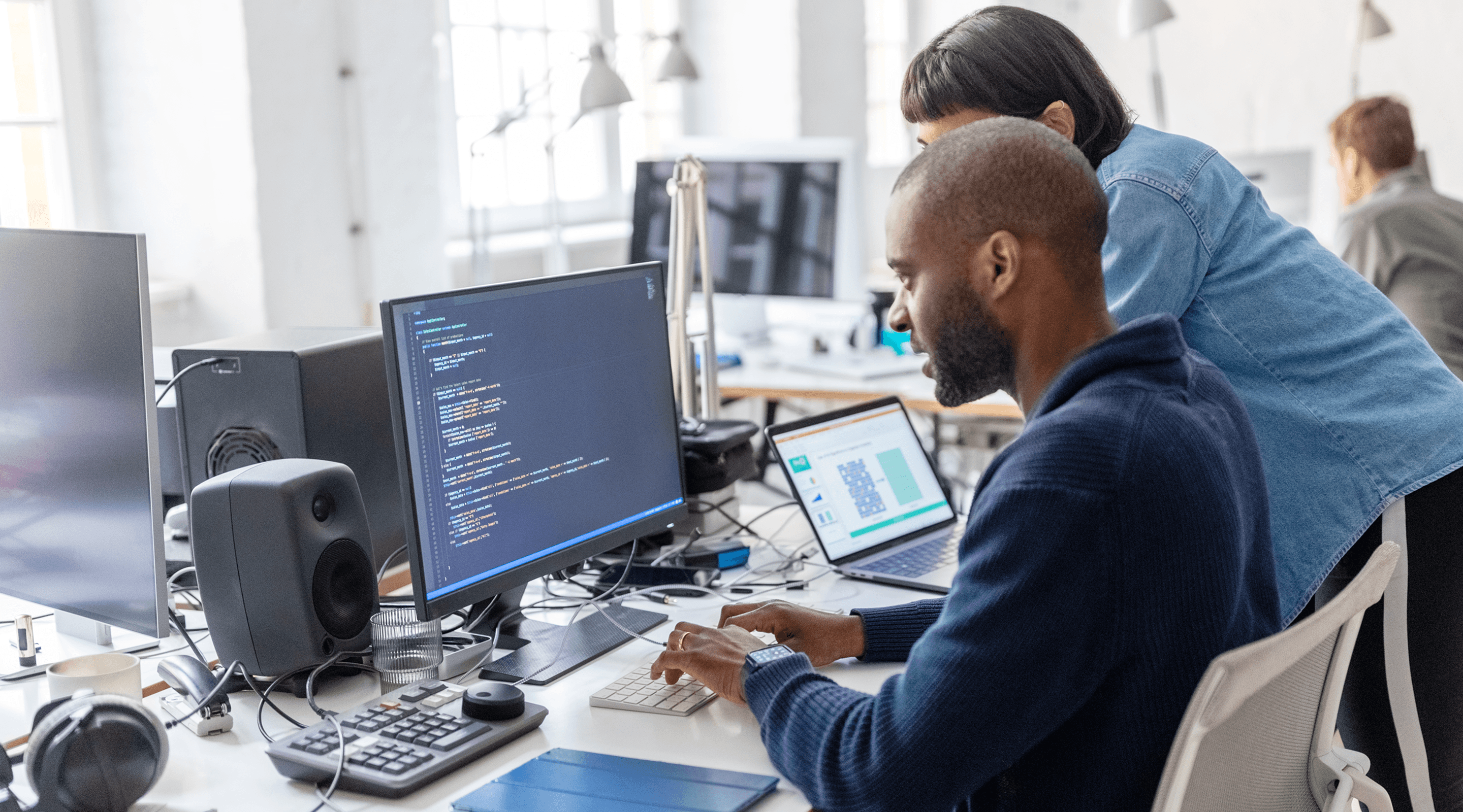 Un hombre y una mujer miran la pantalla de un ordenador.