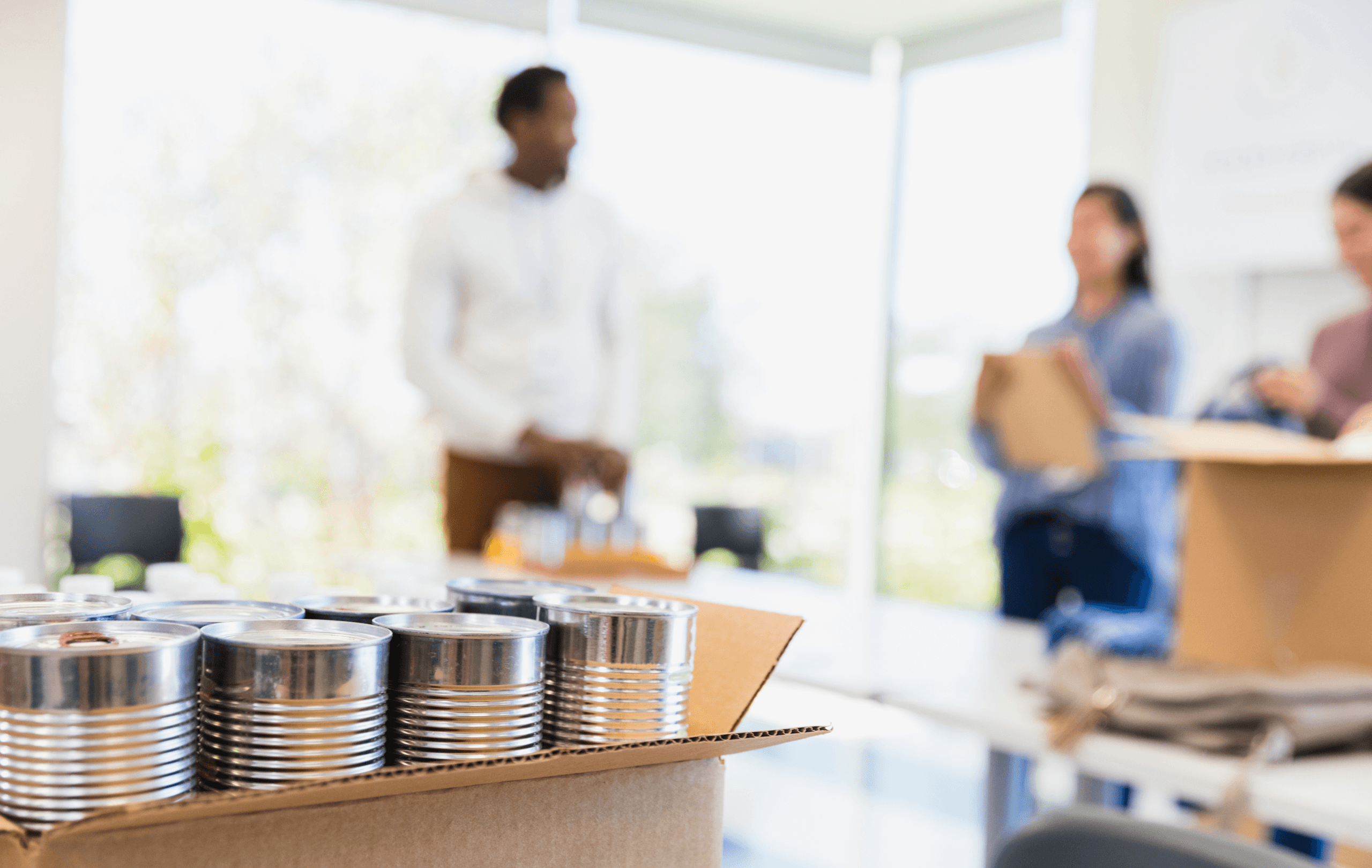 Close of of aluminum cans with man and women standing in the background.
